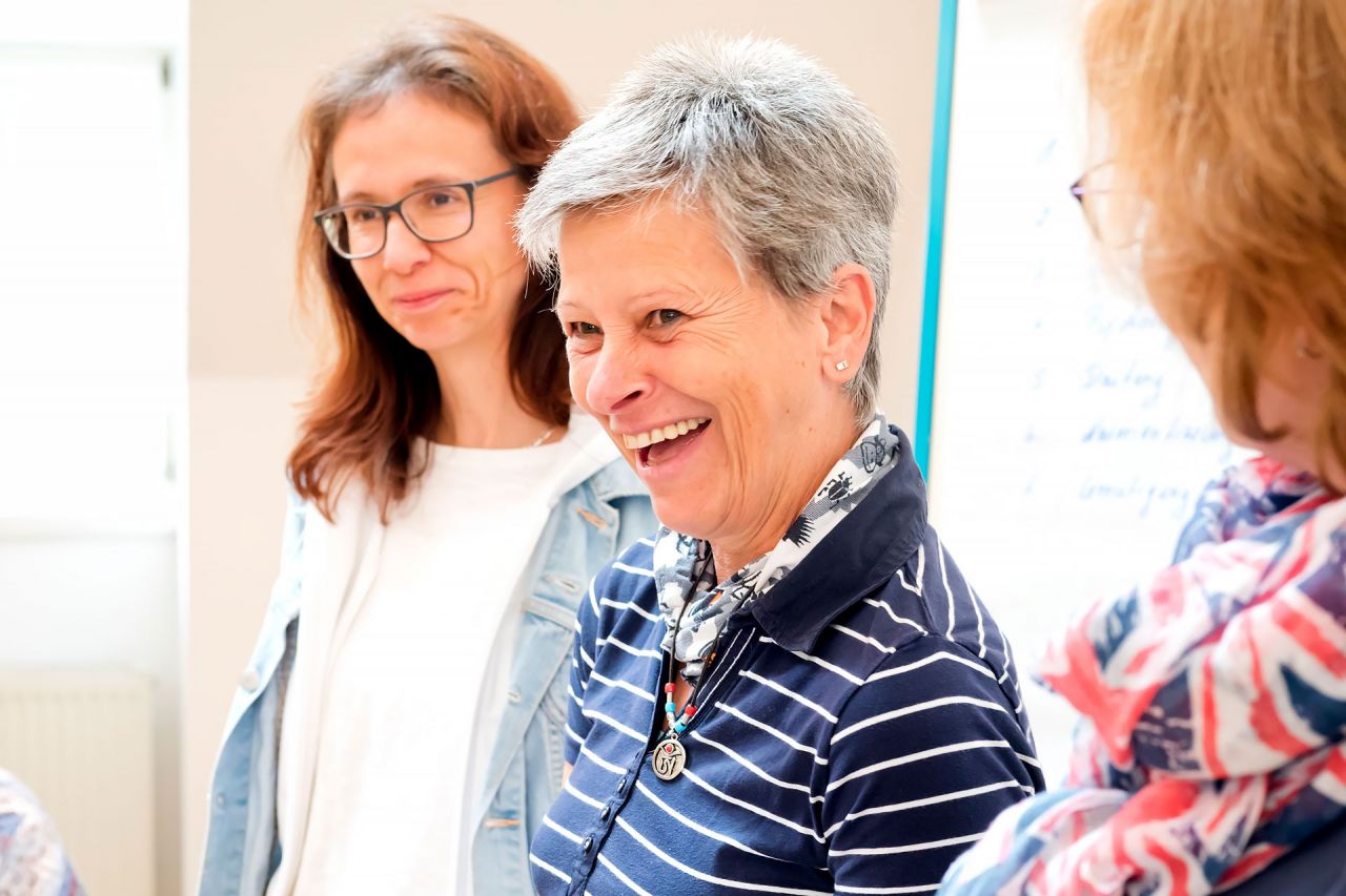Encouraging TrainerIn werden Teilnehmerinnen einer Encouraging-Ausbildung lachen und diskutieren
