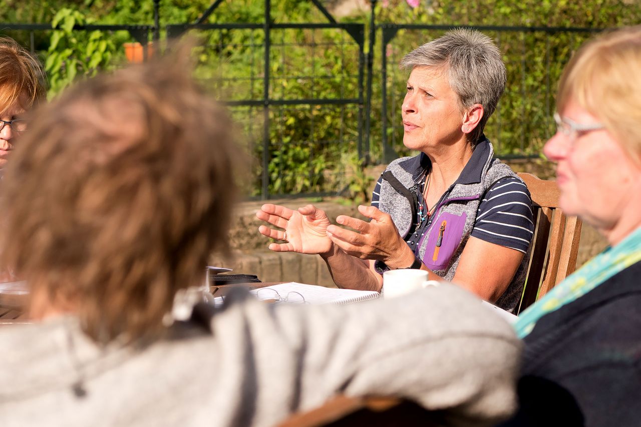 Die Modulausbildung für Coachs und Berater vermittelt wirksame Methoden des Encouraging-Trainings für ihre Praxis Während dem Unterricht der Modul-Ausbildung für Coachs und Berater sitzen die Teilnehmerinnen draussen am Tisch in der Sonne und diskutieren engagiert